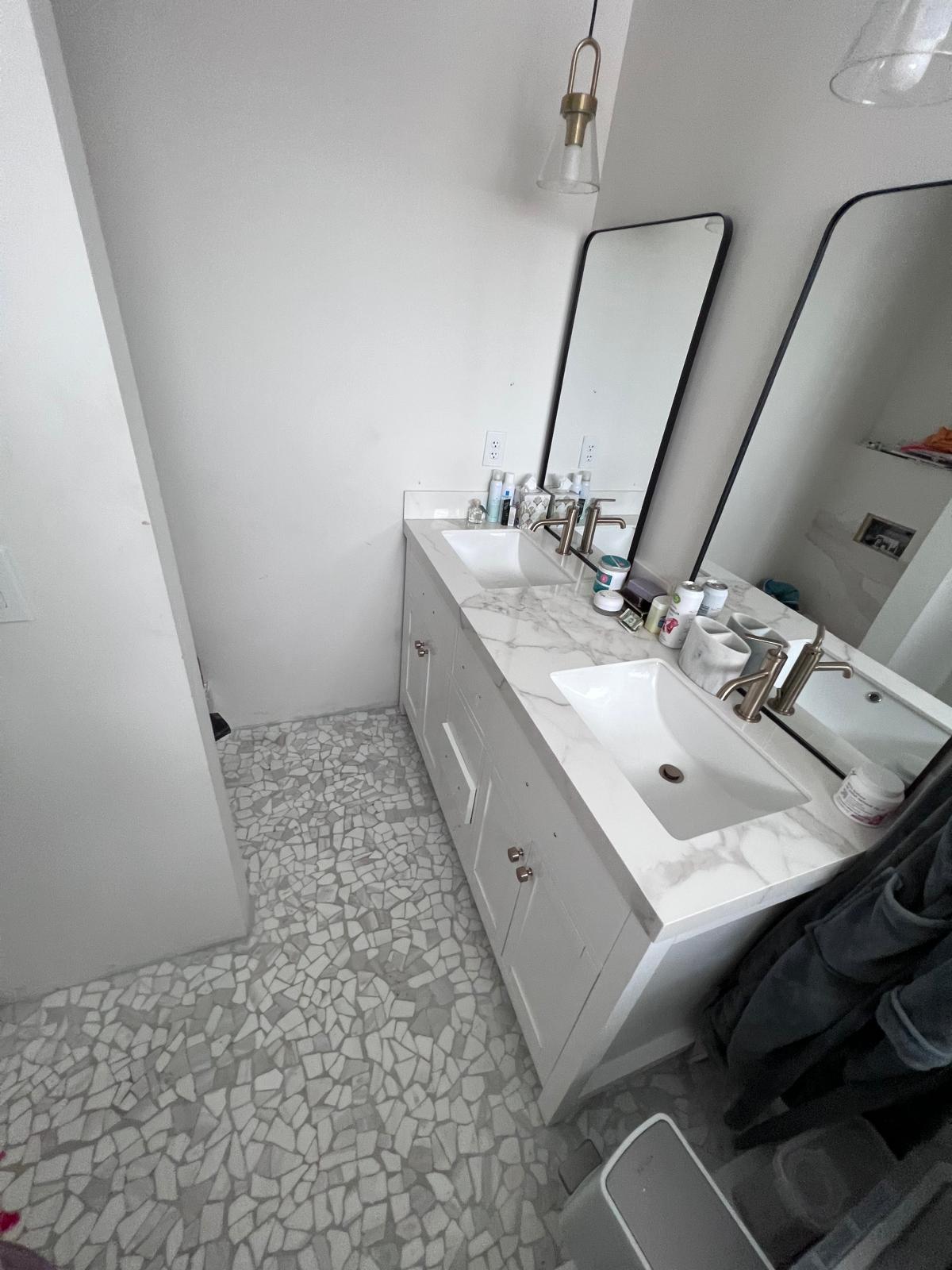 Bathroom sink and vanity after cleaning with organized counters.